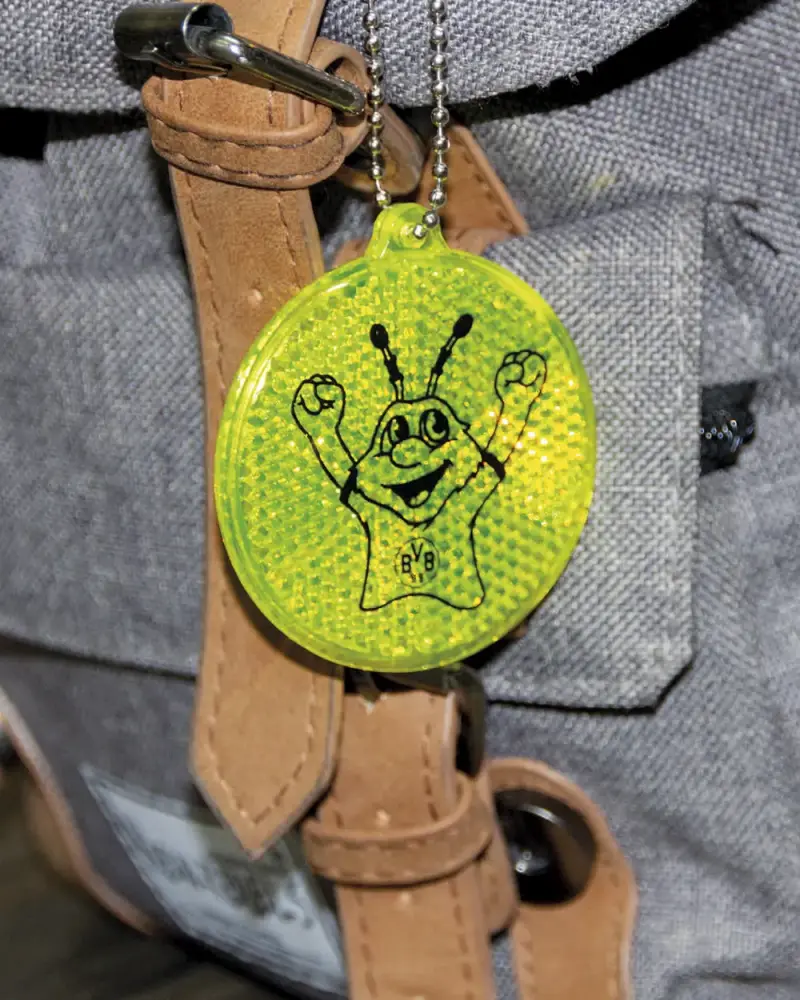 Neongelber Reflektor-Anhänger mit Maskottchen an einer Tasche